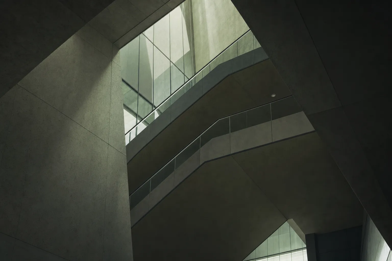Concrete and glass office atrium seen from below